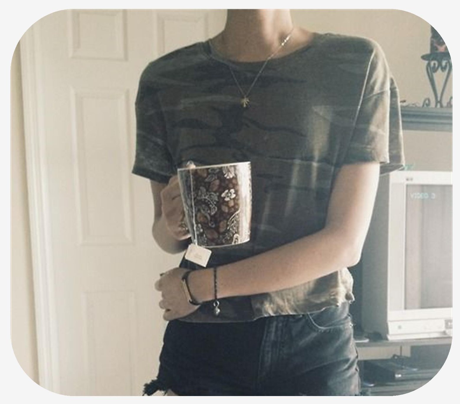Front view a woman with minimal trapezious standing with a cup of coffee in her hand