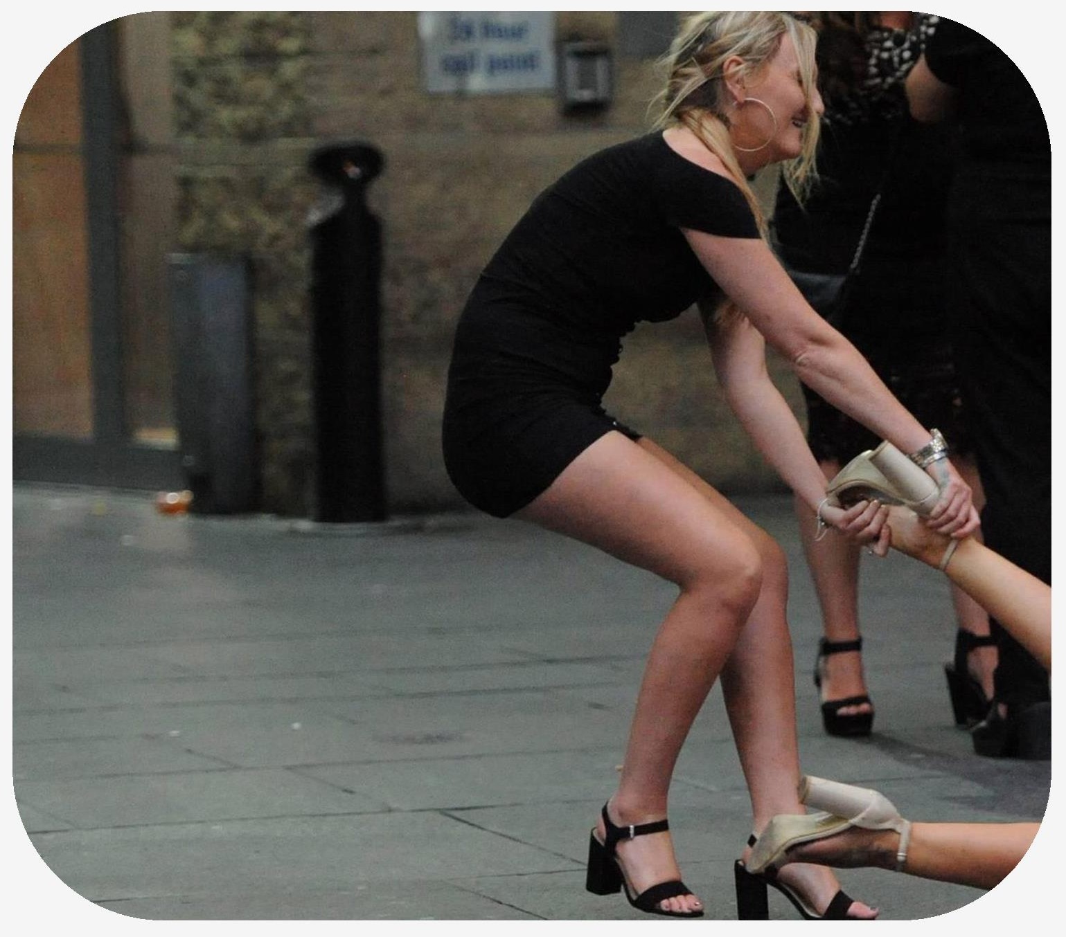 Female playing around by dragging her female friend in a downtown strret