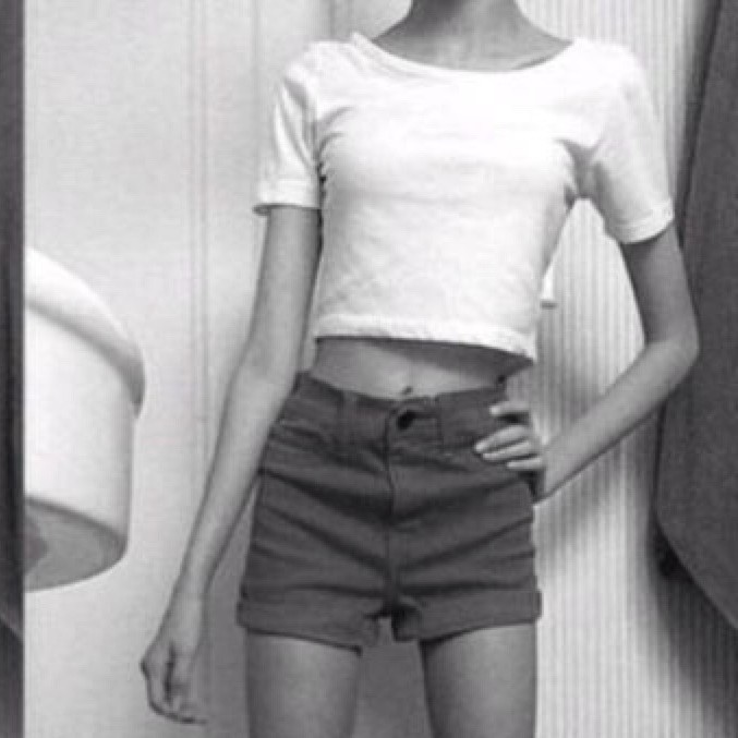 Front view of woman standing with hand on hip.