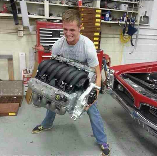 Man lifting an engine