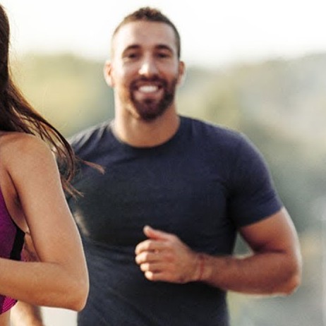 Man jogging right behind a woman
