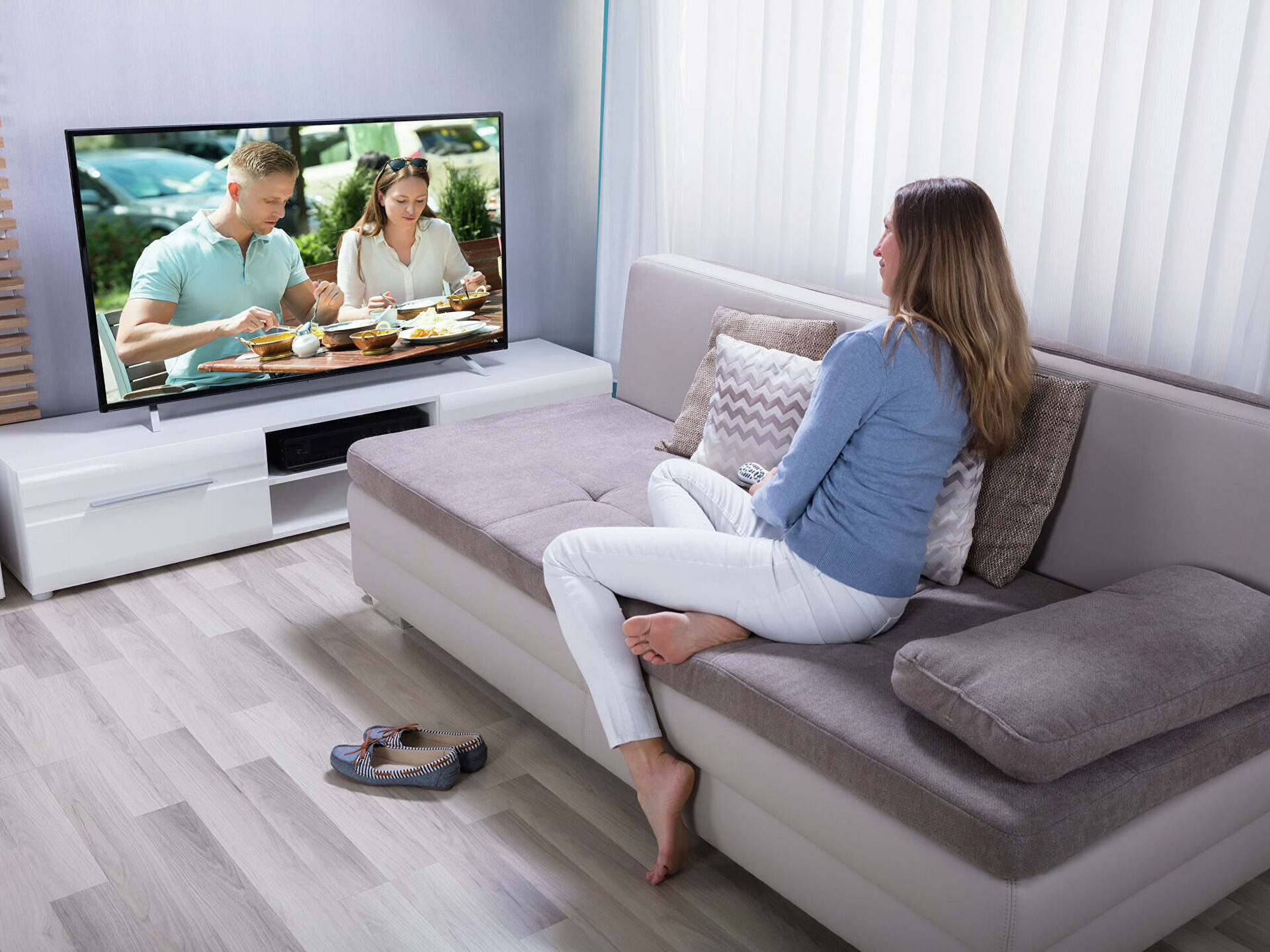 Woman watching TV in a hotel room