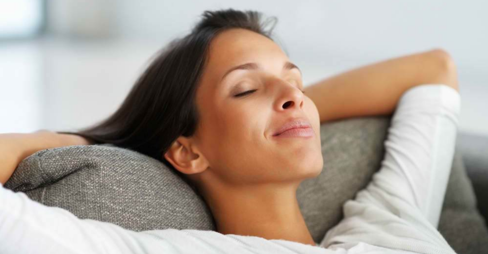 Woman relaxing with her head back on a couch