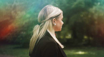 Woman standing at a childhood spot, recalling memories from her childhood.